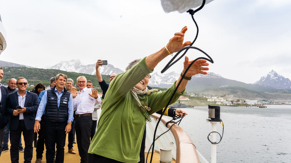 In Ushuaia: Margaret Mortimer throwing a slab of ice to christen Aurora Expeditions' new ship, Greg Mortimer